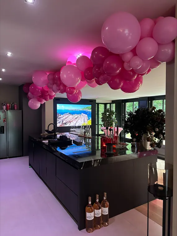 Roze organische ballonguirlande in een feestelijke ruimte
