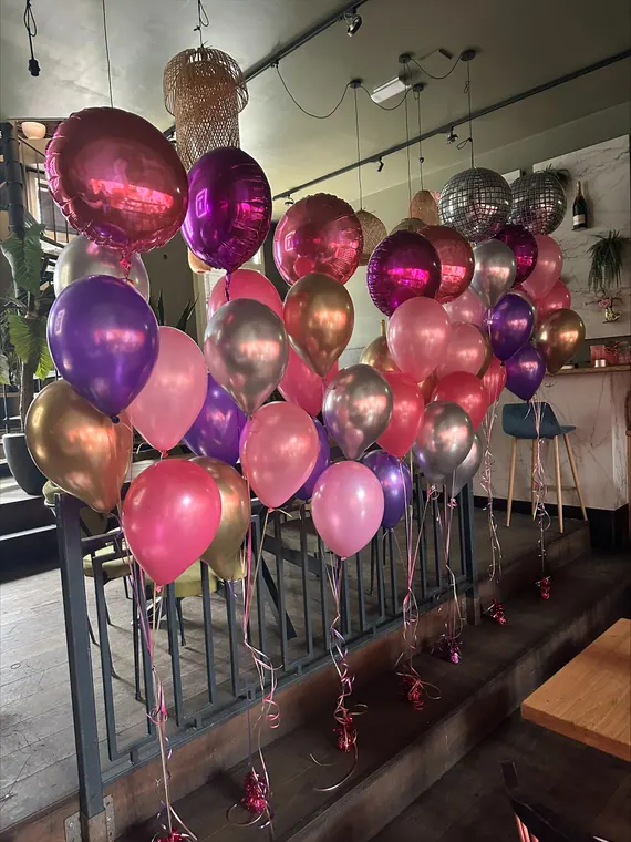 Roze en paarse heliumballonnen in een feestzaal