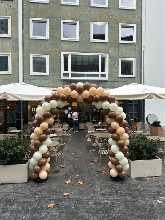 Organische ballonboog in zachte natuurlijke kleuren
