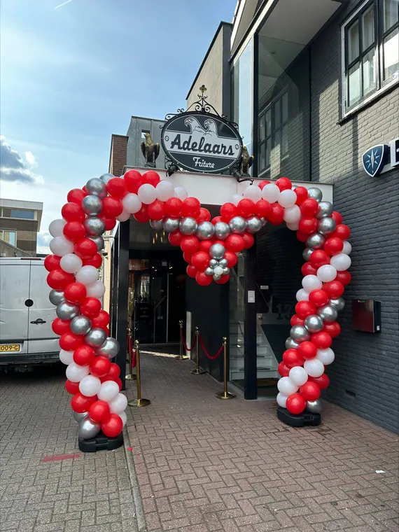 Rood-witte ballonboog bij een winkelentree